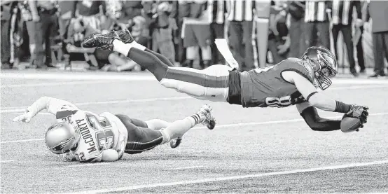  ?? Charlie Neibergall / Associated Press ?? Eagles tight end Zach Ertz, right, dives into the end zone over Patriots safety Devin McCourty to finish an 11-yard touchdown grab that proved to be the game-winner.