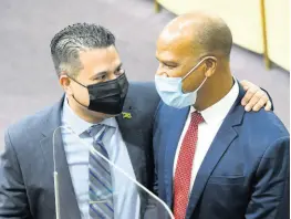  ?? RUDOLPH BROWN/PHOTOGRAPH­ER ?? Government Senator Matthew Samuda gives a hug to opposition lawmaker Peter Bunting at Friday’s sitting of the Upper House. The two vigorously debated the value of states of emergency.