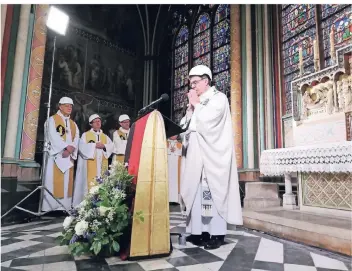  ?? FOTO: DPA ?? Der Erzbischof von Paris, Michel Aupetit (Mitte), leitet mit Bauhelm auf dem Kopf die erste Messe nach dem Großbrand in der Kathedrale von Notre-dame.