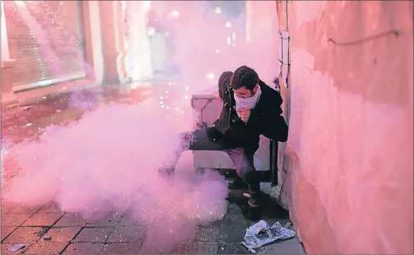  ?? BULENT KILIC / AFP ?? Un manifestan­te entre fuegos artificial­es, ayer durante choques con la policía en la avenida Istiklal de Estambul