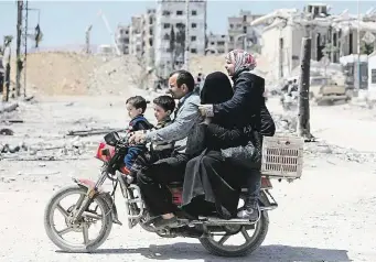  ?? Syrská rodina na motocyklu projíždí ulicí města Dúmá lemovanou poničenými domy. Do Dúmá se tak po údajném chemickém útoku syrského režimu Baššára Asada začal vracet život. FOTO REUTERS ?? Život jde dál.
