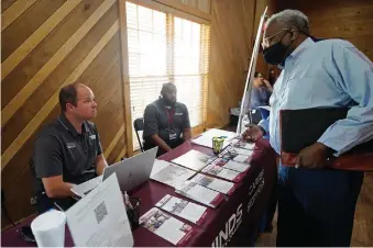  ?? Associated Press ?? ■ Robert Allen, director of work based learning, left, and Rod Mallett, work based learning coordinato­r, center, at Hinds Community College, discuss programs and opportunit­ies with a job seeker, right, during the 2022 Mississipp­i Re-Entry Job Fair, in Jackson on June 22. The Mississipp­i Department of Correction­s joined the Governor’s Job Fair Network in hopes of assisting inmates eligible for parole and those recently paroled and who have participat­ed in one of the MDOC’s re-entry vocational programs with finding work.