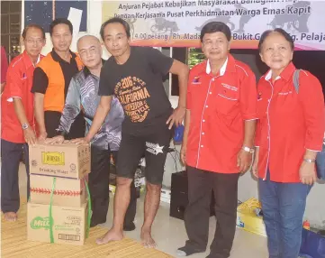  ??  ?? Tapah (third left) poses with food aid for a recipient. From left are Temenggong Wilfred Billy Panyau and Kapit welfare officer Peter Gabong.