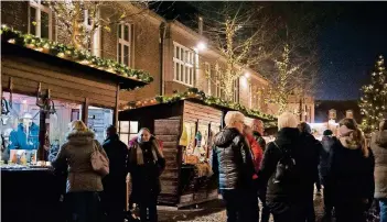  ?? RP-FOTO: RENATE RESCH ?? Auf dem Hückelhove­ner Weihnachts­markt strahlen Buden und Bäume im Lichtergla­nz. Auf der Rathausfas­sade ist täglich zwischen 18 und 20 Uhr eine bunte Video-Lichtshow zu bewundern.
