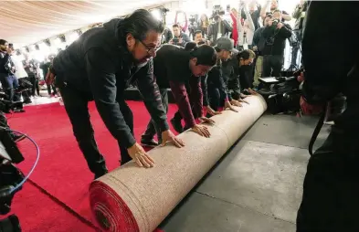  ?? CHRIS PIZZELLO / AP ?? Crew members roll out the red carpet for Sunday’s 96th Academy Awards at the Dolby Theatre in Los Angeles on Wednesday. Executive producer Raj Kapoor said live performanc­es and the “In Memoriam” sequence will be highlights.