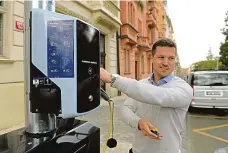  ?? Foto: ČTK ?? Zaparkovat a dobít Mluvčí Technologi­í hlavního města Prahy Martin Drozd předvádí nabíječku elektromob­ilů na lampě veřejného osvětlení.