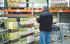  ?? Tim Boyle, Bloomberg file photo ?? A customer shops for wines at a Costco store in Mount Prospect, Ill., in 2012. Alcohol sales have been a bright spot for the company during tough times.