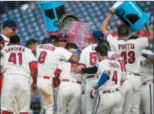  ?? LAURENCE KESTERSON — THE ASSOCIATED PRESS ?? Phillies’ Andrew Knapp (15), center, is doused by teammates at home plate after hitting a walk-off home run in the 13th inning on Sunday.