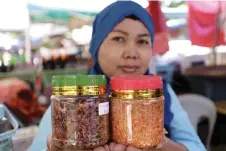  ?? — Bernama photos ?? Trader Anis Haris sells jeruk tuhau and serunding tuhau at the Donggongon market.