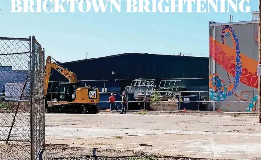  ?? [PHOTO BY STEVE LACKMEYER, THE OKLAHOMAN] ?? Crews start work on a planned parking lot at 420 E Sheridan Ave. on Monday. The “Bricktown Octopus” mural and the Brewer Entertainm­ent loading dock can be seen in the foreground.
