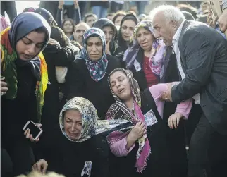  ?? BULENT KILIC/AFP/GETTY IMAGES ?? Relatives mourn a victim of suicide bombings in Ankara during a funeral in Istanbul on Monday. At least 95 people were killed at a peace rally on Saturday.