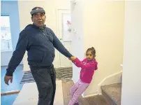  ??  ?? Ganay, 6, urges her father upstairs to bedrooms the family now has in their Brampton townhome.