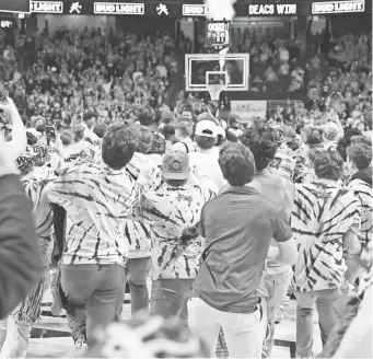  ?? CORY KNOWLTON/USA TODAY SPORTS ?? Wake Forest students storm the court after the school’s defeat of Duke at Lawrence Joel Veterans Memorial Coliseum.