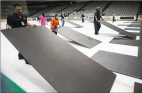  ?? ASHLEY LANDIS - THE ASSOCIATED PRESS ?? Crews cover the ice at American Airlines Center in Dallas, home of the Dallas Stars hockey team, after the NHL season was put on hold due to coronaviru­s, Thursday, March 12, 2020.