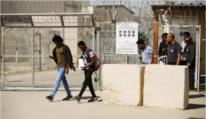  ??  ?? AFRICAN MIGRANTS walk out after being released from Saharonim Prison yesterday in the Negev.