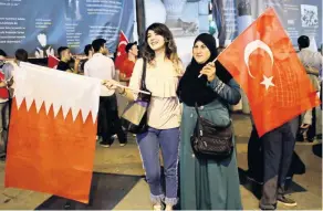  ??  ?? Mujeres posan con las banderas de Qatar (izq.) y Turquía, durante una manifestac­ión celebrada ayer en Estambul para apoyar al gobierno de Doha.