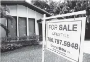  ?? LYNNE SLADKY AP ?? Real estate experts disagree on whether national housing prices will fall in the months ahead. A sale sign hangs in front of a house in Miami in 2015.