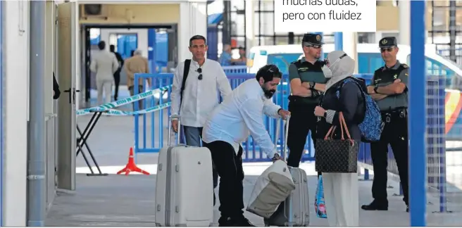  ?? REPORTAJE GRÁFICO: ERASMO FENOY ?? Varias personas cruzan la frontera del Tarajal en presencia de dos guardias civiles.