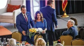  ?? JIM NOELKER / STAFF ?? Ohio Lt. Gov. Jon. Husted and his wife, Tina, present Maureen Patterson with flowers Wednesday at the Dayton Developmen­t Coalition’s meeting at Carillon Historical Park after Husted received the Maureen Patterson Regional Leader Award.