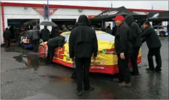  ?? BUTCH DILL — THE ASSOCIATED PRESS ?? Crew members for Joey Logano push his car to be inspected at Talladega Superspeed­way on Friday in Talladega, Ala.