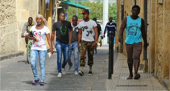  ??  ?? Refugee camp: Migrants walk the streets of the Sicilian town of Mineo, whose mayor says: ‘Our tolerance level is way over the limit’