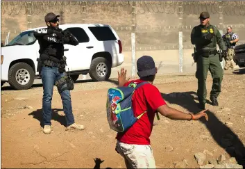  ?? AP PHOTO/PEDrO ACOSTA ?? A Central American migrant is stopped by U.S. agents who order him to go back to the Mexican side of the border, after a group of migrants got past Mexican police at the Chaparral crossing in Tijuana, Mexico, on Sunday at the border with San ysidro, California.