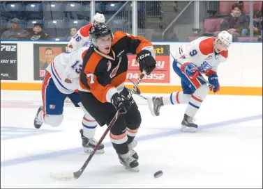  ?? NEWS PHOTO RYAN MCCRACKEN ?? Medicine Hat Tigers forward Hayden Ostir makes a breakout pass while former Tiger Zach Fischer gives chase during the first period of Wednesday's Western Hockey League game at the Canalta Centre.