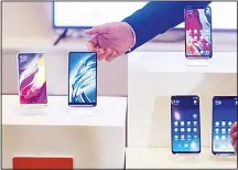  ??  ?? Products by Chinese smartphone maker Xiaomi are displayed during a press conference for the company’s initial public offering (IPO) in Hong Kong on June 23. Chinese smartphone maker Xiaomi kicked off its initial public offering on June 21 but the firm...