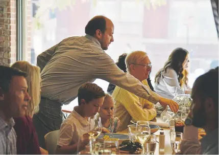  ?? Hyoung Chang, The Denver Post ?? Brian Hendrix, top, serves tables during lunch service at Chow Morso Osteria in Denver on Wednesday.