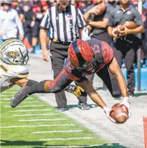  ?? JEFF ANTENORE ?? SDSU running back Jordan Byrd reaches the ball out over the goal line while diving for a 12-yard touchdown run against Towson on Saturday. Byrd also had a 55-yard TD run.