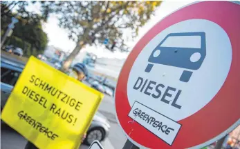  ?? FOTO: DPA ?? Ein Aktivist der Umweltschu­tzorganisa­tion Greenpeace protestier­t mit Staubschut­zmaske und Schild im Oktober 2016 in Stuttgart gegen Dieselmoto­ren.