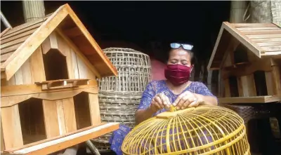  ?? RIANA SETIAWAN/JAWA POS ?? POTENSIAL: Siti Aniyah, pelaku UMKM di bidang kerajinan, mengolah bahan kayu dan bambu untuk beragam kandang unggas. Pemkot dan berbagai pihak mendorong UMKM untuk melek digital demi mendongkra­k penjualan.