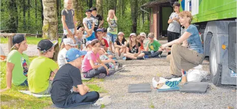  ?? FOTO: CHRISTOPH KLAWITTER ?? Naturpädag­ogin Sabine Reußink erklärt den Viertkläss­lern das Leben im Wald.