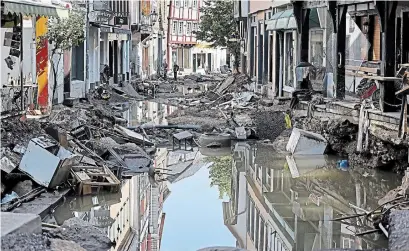  ?? OLIVER BERG THE ASSOCIATED PRESS ?? The flood-ravaged town centre in Bad Muensterei­fel, western Germany, on Sunday. Multiple people have died and are missing as heavy rains in Germany turned streams and streets into debris-filled torrents that swept away cars and toppled houses.