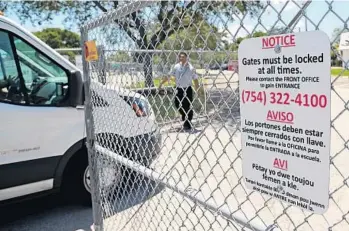  ?? AMY BETH BENNETT/STAFF PHOTOGRAPH­ER ?? Security specialist Nestor Montanez opens the gate for a Broward County School District vehicle at Plantation Middle School on Thursday. Many schools, especially in Broward, now restrict visitor access.