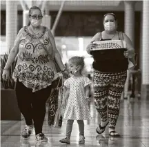  ?? Jason Fochtman / Staff photograph­er ?? Shoppers get back to enjoying The Woodlands Mall, which reopened its doors at 25% capacity after being closed 40 days.