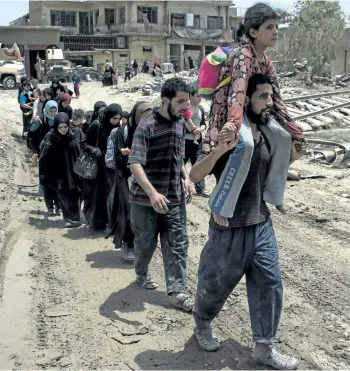  ?? GETTY IMAGES ?? Iraqi civilians flee the Old City of Mosul, Iraq, on Monday, during the government forces’ ongoing offensive to retake the city from Islamic State fighters.