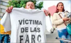  ?? RAUL ARBOLEDA/AFP ?? A woman holds a T-shirt reading ‘Victim of the FARC’ during a protest outside the Special Jurisdicti­on for Peace headquarte­rs in Bogota on Saturday.