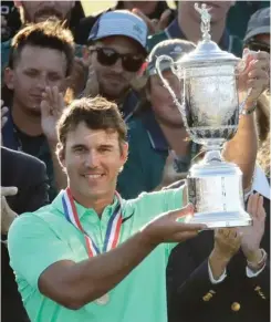  ?? (Photo by Charlie Riedel, AP) ?? Brooks Koepka holds up the winning trophy after the U.S. Open on Sunday.