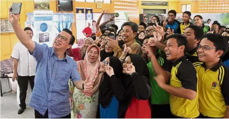  ??  ?? Green generation: Liow posing for a wefie with students from SMK Sulaiman in Bentong after reminding them of the importance of caring for the environmen­t.