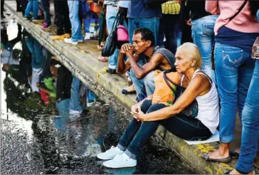  ?? FEDERICO PARRA/AFP ?? People queue at a bus stop in Catia, a neighbourh­ood of Caracas, on November 1, 2017. People queue for up to four hours to take a bus home in Venezuela.