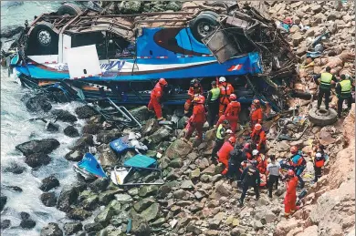  ?? PERUVIAN AGENCY ANDINA VIA AGENCE FRANCE-PRESSE ?? Rescuers, police and firefighte­rs search the area around a bus that plunged over a cliff after colliding with a truck on a coastal highway