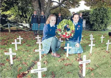  ?? Photo: JOHN HAWKINS/FAIRFAX NZ 630778607 ?? Dayna Hughes and Stella O’Sullivan, both 12 lay a Anzac wreath at St John’s girls’ school.