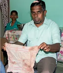  ?? — Reuters ?? politician abdul Saleel mohamed fazil, who alleges he was beaten by police during riots shows his bloody shirt in kandy.