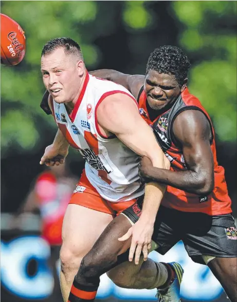  ?? Picture: DANIEL HARTLEY-ALLEN ?? Waratahs’ Mitchell Sandery is caught by Tiwi Bombers’ Ross Tungatalum during the Warriors’ two-point win at Gardens Oval yesterday that was sealed in the dying stages by a bag of seven goals to Davin Hall