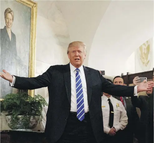  ?? EVAN VUCCI / THE ASSOCIATED PRESS ?? U.S. President Donald Trump greets the first wave of tourists to come through the White House since he assumed office, welcoming a small crowd of visitors to the East Wing on Tuesday, as spectators cheered and took photos.