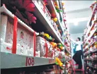  ?? WANG ZHILONG / FOR CHINA DAILY ?? A worker at a funeral parlor in Xiamen, Fujian province, arranges cinerary caskets.