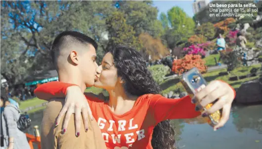  ?? FERNANDO DE LA ORDEN ?? Un beso para la selfie. Una pareja de 15, al sol en el Jardín Japonés.