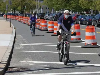  ?? Angela rowlings / Herald staFF ?? OFF TRACK: Bicyclists ride along a protected area of Day Boulevard on Thursday. Enjoy the warmth while you can — temps are expected to drop Saturday.