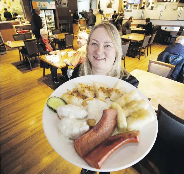  ?? PHOTOS: DAVID BLOOM ?? Colette Hennig offers up a combo plate featuring perogies, cabbage rolls, cheese buns, cheese crepes and sausage.